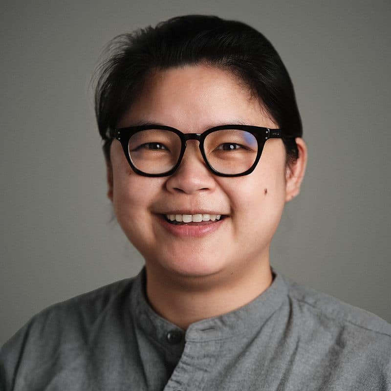 a woman wearing glasses and smiling