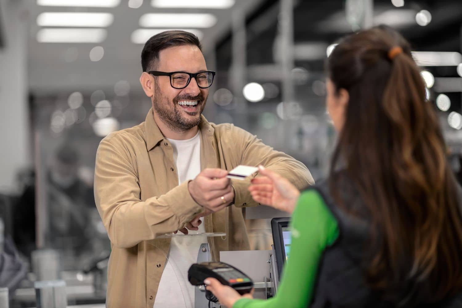 a man handing a credit card to a woman